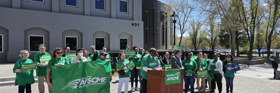 AFSCME Nevada members in green at a rally holding signs that say AFSCME and State Workers Have Solutions